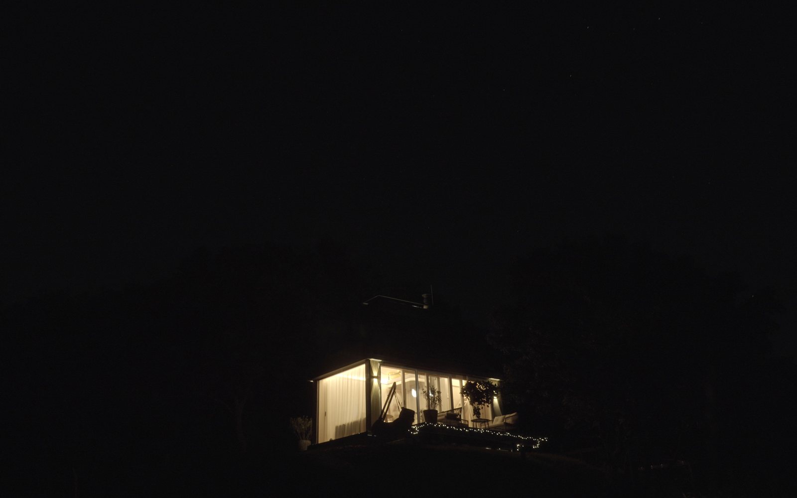 Cabin Devín lit up at night above the vineyards